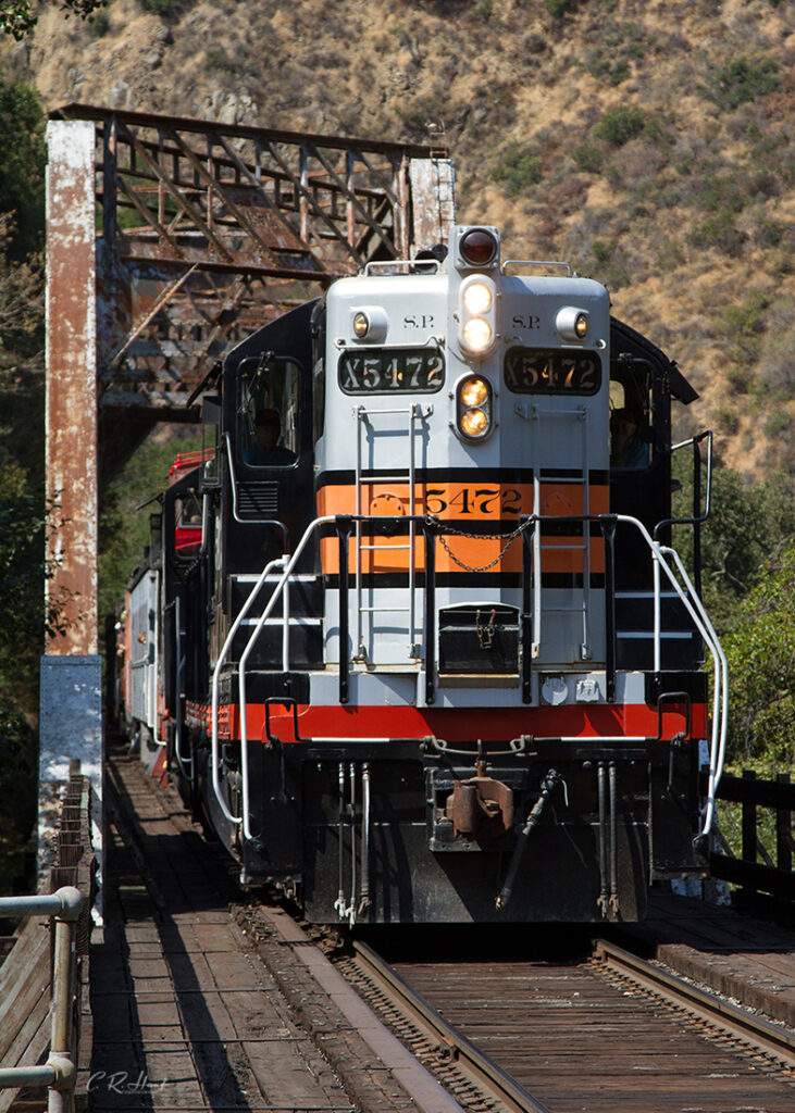 Diesel locomotive passing over steel truss bridge